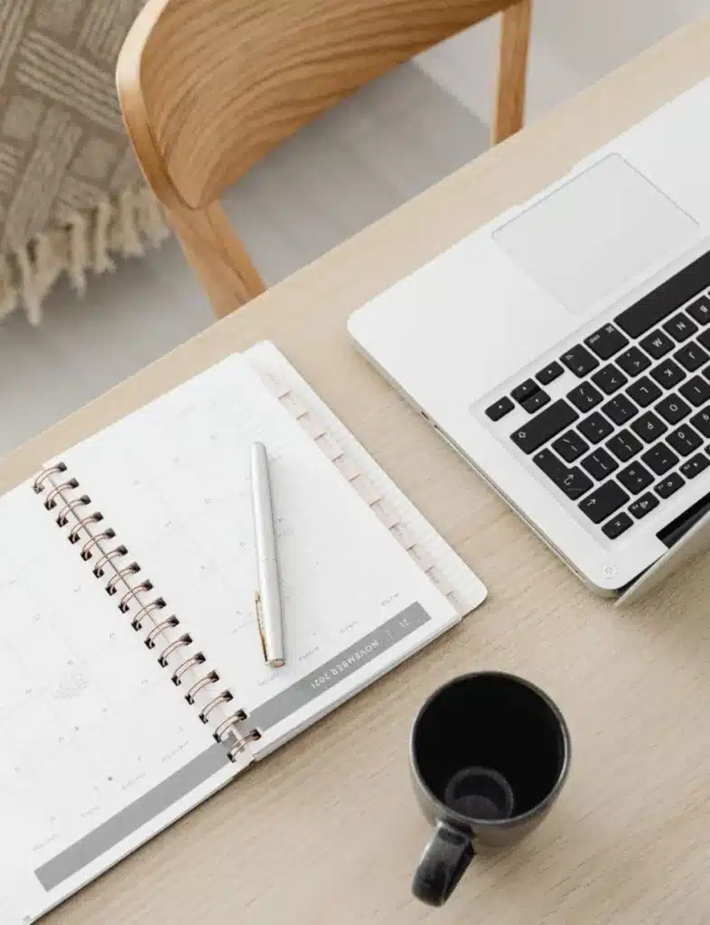 Bureau épuré avec ordinateur et agenda : votre organisation administrative à distance.